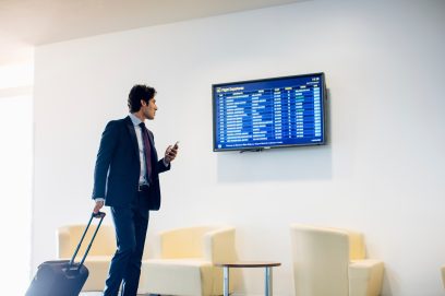 Businessman checking flight information at the airport lounge Businessman checking flight information at the airport lounge